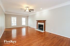 Winston Salem house for rent - A spacious room with a fireplace and wooden floors.