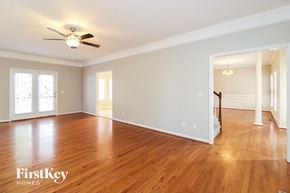 Winston Salem house for rent - A spacious room with wooden floors and a ceiling fan.