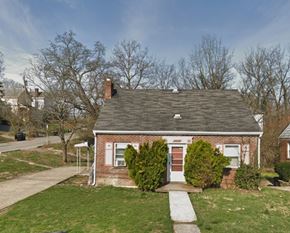 Cincinnati house for rent - A small brick house with a red door and a chimney.