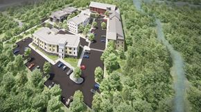 Medway apartment for rent - Aerial view shows buildings with parking surrounded by woods with a small river behind.