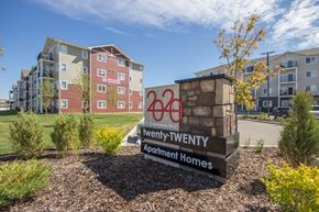 Red Deer apartment for rent - A sign for Twenty-Twenty Apartment Homes stands in front of a building.