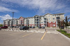 Red Deer apartment for rent - A parking lot in front of a multi-story apartment building.