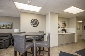 Red Deer apartment for rent - A conference room with a clock on the wall and a couch.