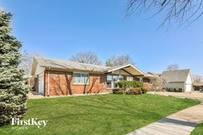 St Louis house for rent - a brick house with a green lawn and a sidewalk