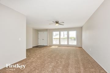 St Louis house for rent - a spacious living room with carpet and a ceiling fan