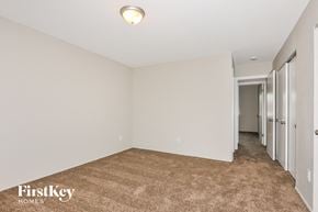 St Louis house for rent - a master bedroom with a carpeted floor and white walls