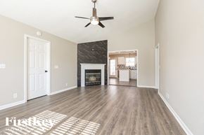 Antioch house for rent - A spacious living room with a fireplace and a ceiling fan.