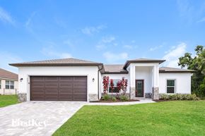 North Port house for rent - a white house with a brown garage door and a green lawn