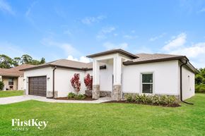 North Port house for rent - a white house with a lawn and a garage