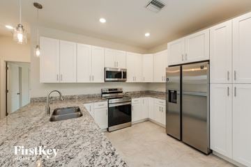 North Port house for rent - a white kitchen with granite counter tops and stainless steel appliances