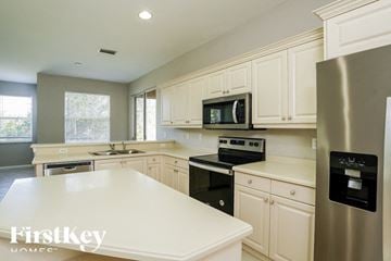 Lehigh Acres house for rent - A kitchen with white cabinets and a stainless steel refrigerator.