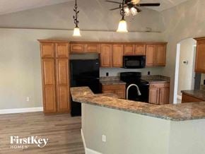 North Port house for rent - an empty kitchen with wooden cabinets and a counter top