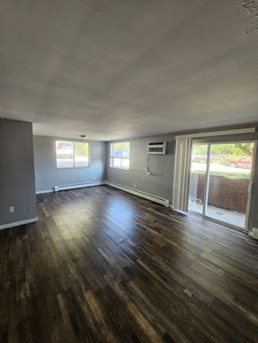 Bethel apartment for rent - A room with wooden floors and a sliding glass door.