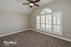 Cypress house for rent - the master bedroom has a ceiling fan and a large window