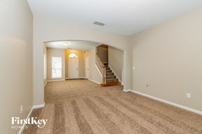 Orange Park house for rent - a spacious living room with carpeting and a staircase