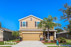 Ruskin house for rent - a yellow house with a palm tree in front of it