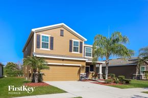 Ruskin house for rent - a yellow house with palm trees in front of it