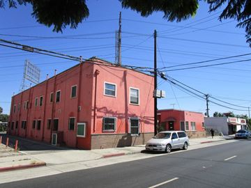Long Beach apartment for rent - a red building on the corner of a street with a car