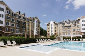 Garfield apartment for rent - a swimming pool with chairs in front of an apartment building