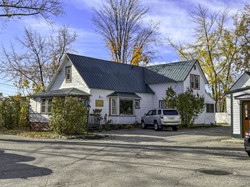 North Conway apartment for rent - A white house with a black roof and a silver car parked in front.