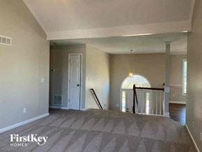 Powder Springs house for rent - an empty living room with a staircase and a white door