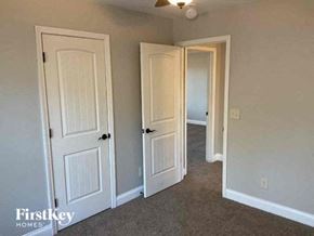 Buford house for rent - a bedroom with three doors and a carpeted floor