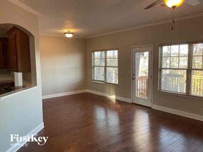 Buford house for rent - an empty living room with wood floors and a door