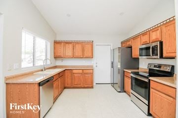 Mesa house for rent - a large kitchen with wooden cabinets and stainless steel appliances