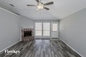 Fort Worth house for rent - a living room with a fireplace and a ceiling fan