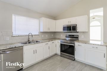 Fort Worth house for rent - a kitchen with white cabinets and stainless steel appliances