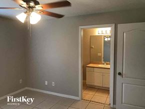 Lehigh Acres house for rent - a bedroom with a ceiling fan and a bathroom with a sink