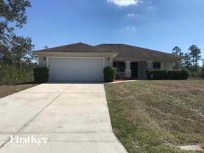 Lehigh Acres house for rent - a house with a driveway and a garage door