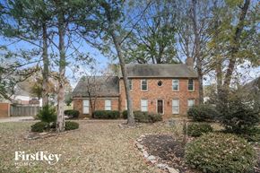 Collierville house for rent - a brick house with a gravel driveway and trees