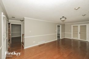Collierville house for rent - an empty living room with a hard wood floor and white walls