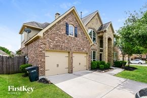 Cypress house for rent - the front of a brick house with a garage door