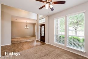 Cypress house for rent - an empty living room with a ceiling fan and a large window