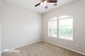 Cypress house for rent - a bedroom with a ceiling fan and a window