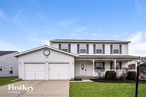 Indianapolis house for rent - a white house with white garage doors and a lawn