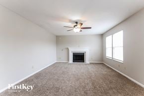 Indianapolis house for rent - an empty living room with a ceiling fan and a fireplace