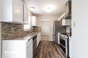 Indianapolis house for rent - a kitchen with white cabinets and stainless steel appliances