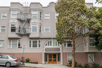 San Francisco apartment for rent - A grey building with a tree in front of it.