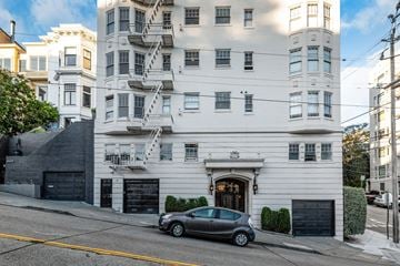San Francisco apartment for rent - A white building with a grey car parked in front.
