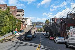 San Francisco apartment for rent - A street view with cars parked on the side and a white van parked on the side of the road.