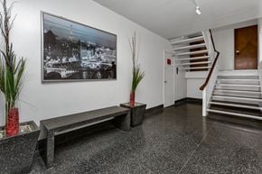 San Francisco apartment for rent - A black and white photo of a cityscape is hanging on a white wall above a bench.