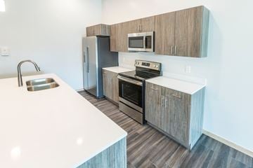 South Sioux City apartment for rent - a kitchen with stainless steel appliances and wooden cabinets
