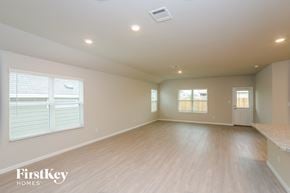 San Antonio house for rent - A spacious empty room with wooden flooring and a window with blinds.