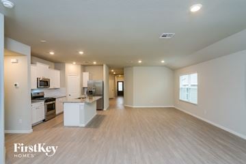 San Antonio house for rent - A spacious kitchen with white appliances and wooden flooring.