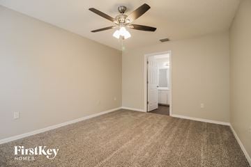Deltona house for rent - the spacious living room with ceiling fan and carpet