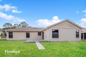 Deltona house for rent - a white house with a grassy yard and a sidewalk