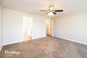 Whitsett house for rent - A spacious room with a carpeted floor and a ceiling fan.